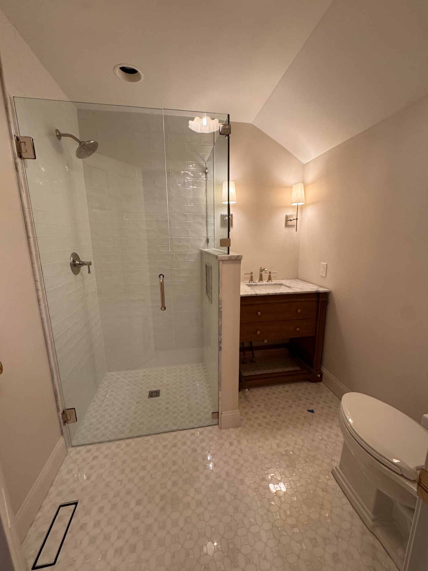 Master bathroom remodel with white zellige subway tile, frameless glass shower, penny mosaic floor, and walnut floating vanity in Northeast Ohio