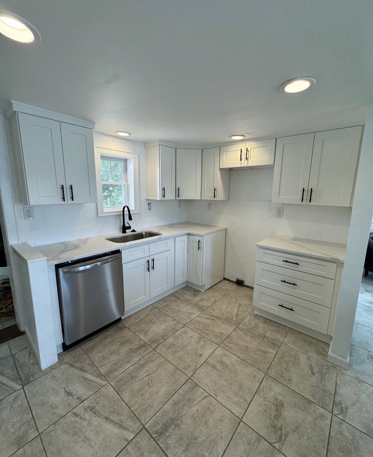 Kitchen remodel with white shaker cabinets, stone countertops, and tile backsplash in Lake County Ohio