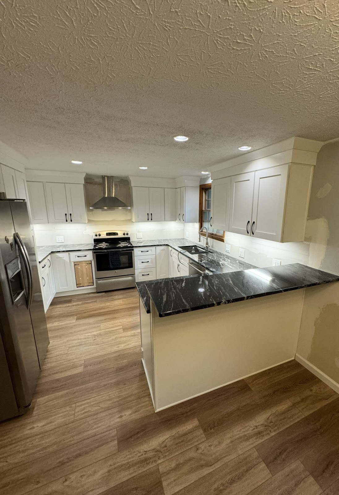 Kitchen remodel with custom cabinetry, quartz island, and hardwood floors in Northeast Ohio