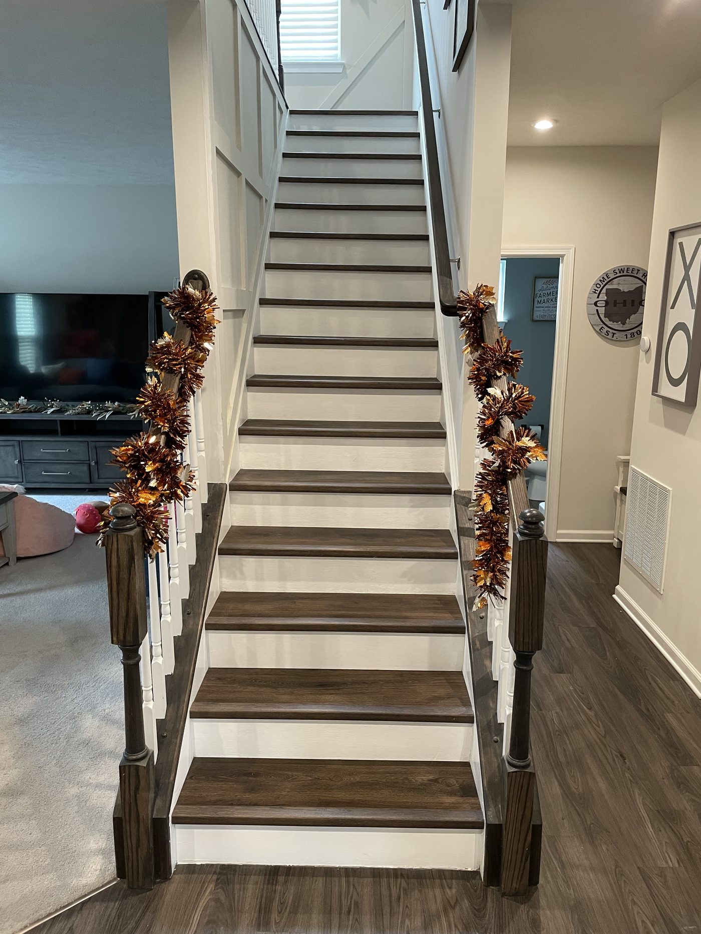 Dark walnut hardwood stair treads with white painted risers and iron railing in Lake County Ohio home