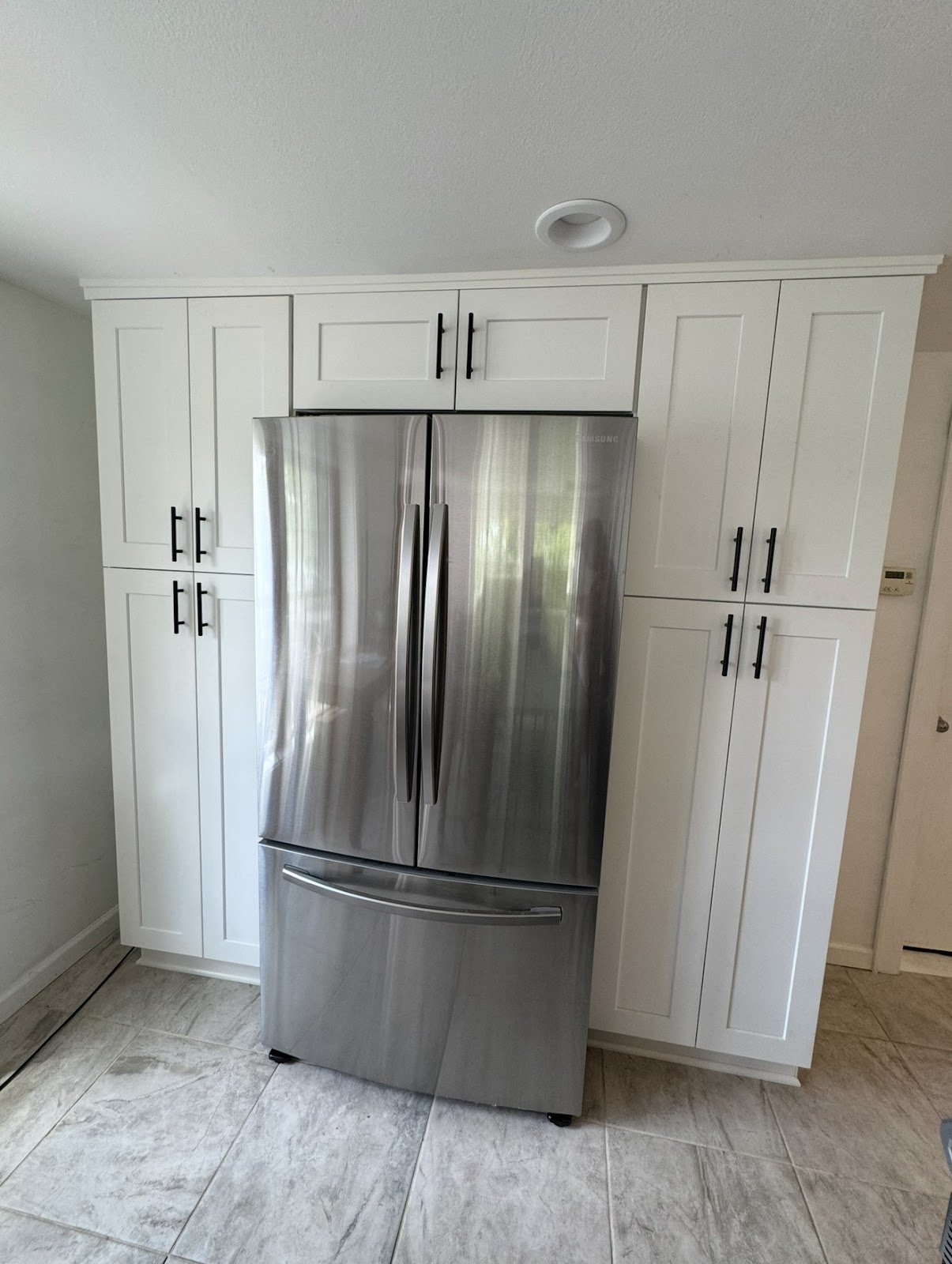 Kitchen remodel with white cabinetry, premium countertops, and tile backsplash in Cuyahoga County