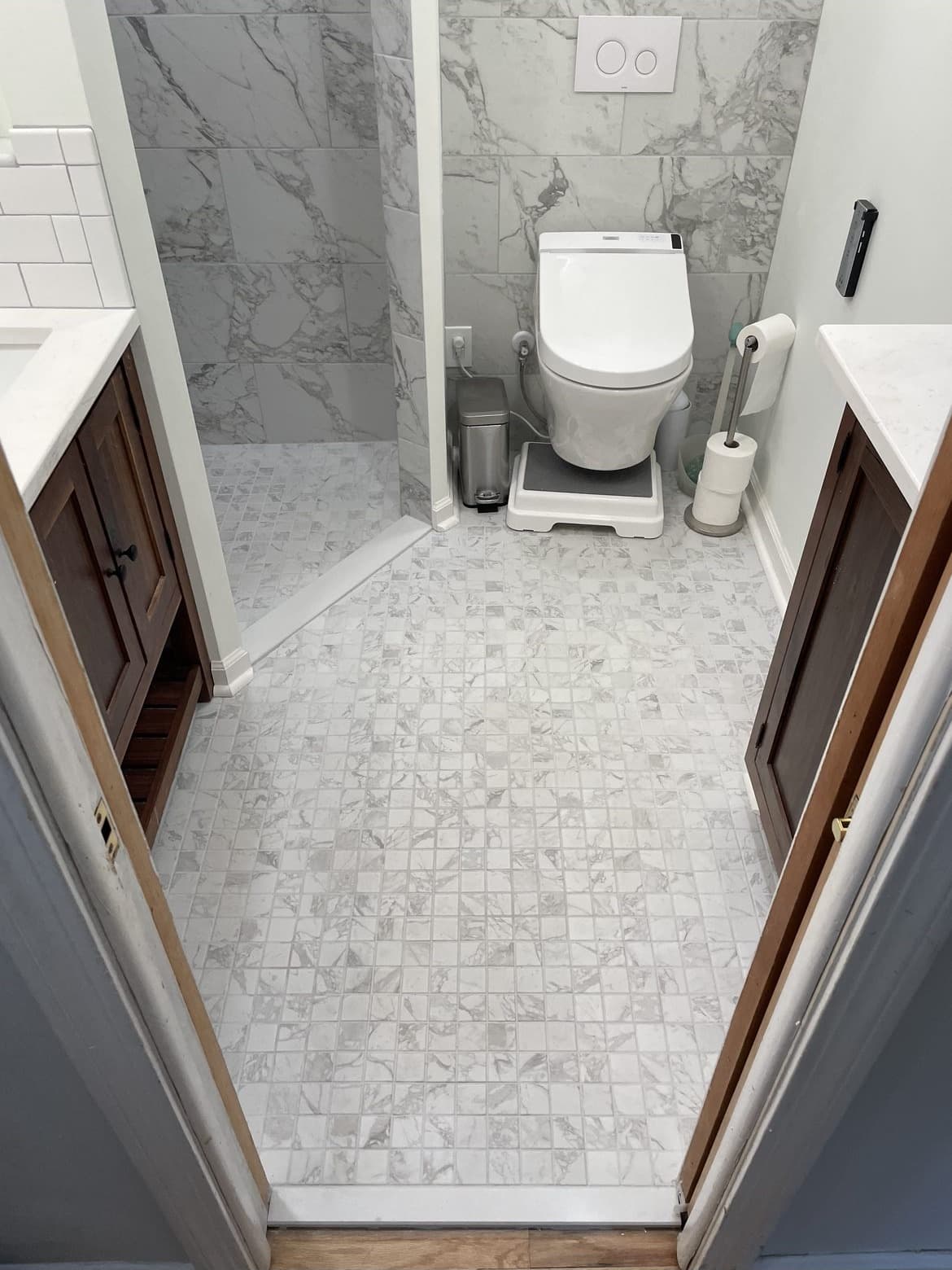 Bathroom remodel with large-format white marble tile floor and marble accent wall in Lake County Ohio