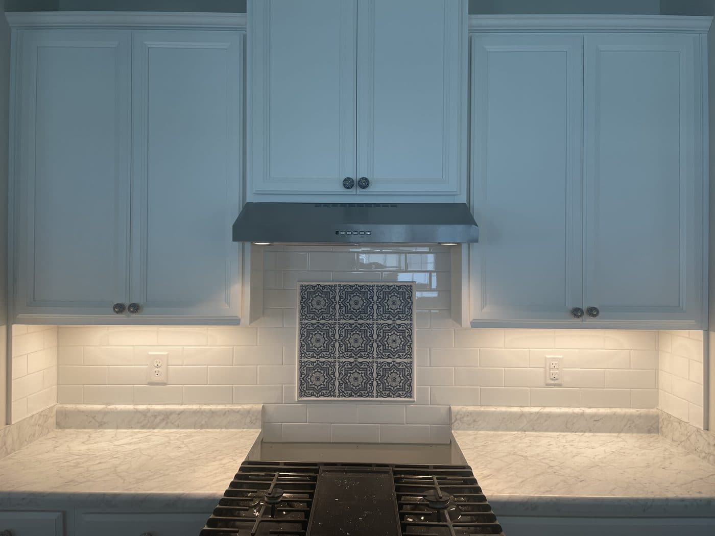 Kitchen remodel with light blue shaker cabinets, white subway tile, Moroccan cement accent tile, and marble countertops in Lake County Ohio