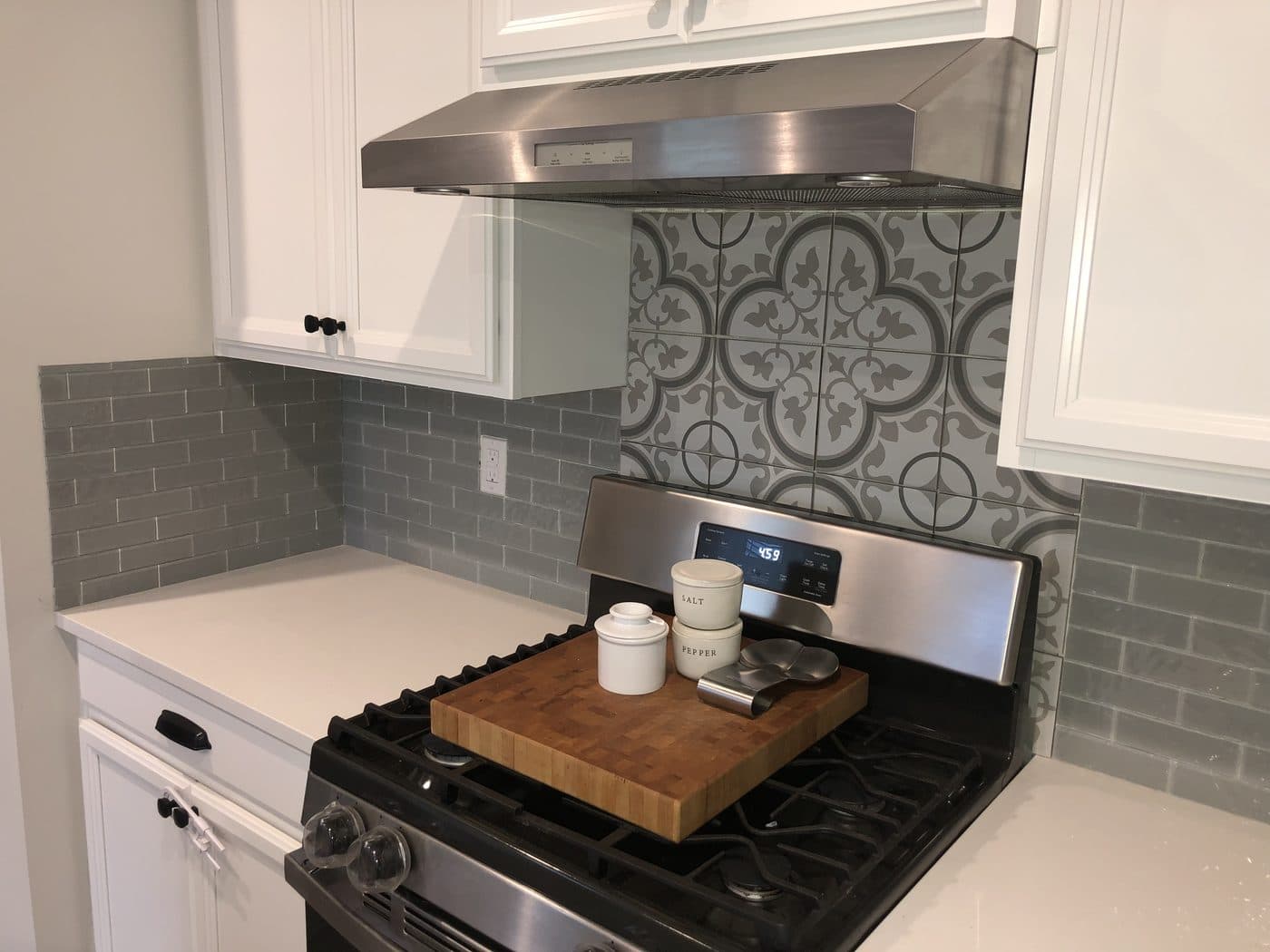 Kitchen remodel with white cabinets, grey Victorian-pattern Moroccan accent tile backsplash, and white quartz countertops in Northeast Ohio