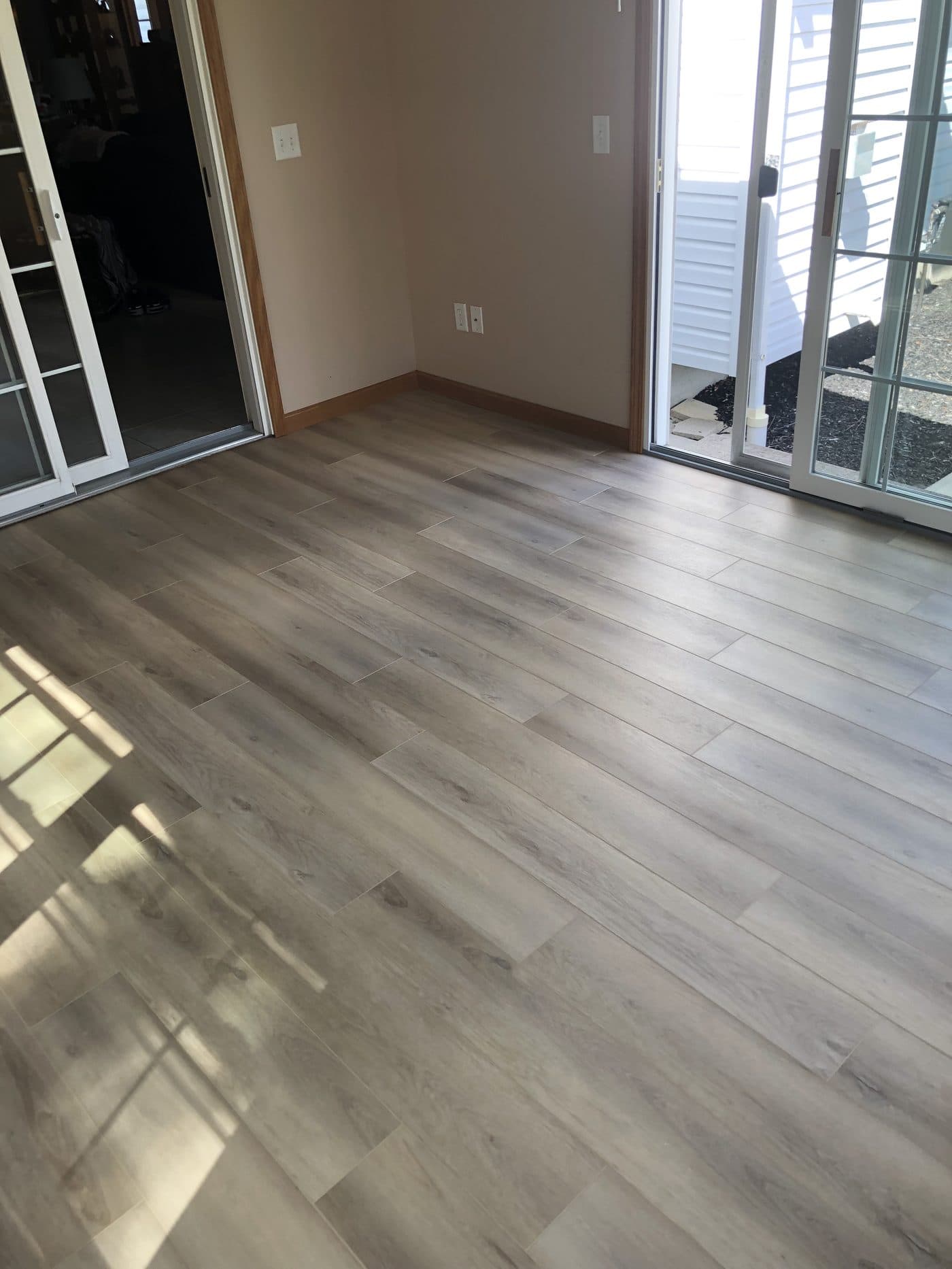 Light grey wide-plank LVP flooring with French double glass doors in Cuyahoga County home