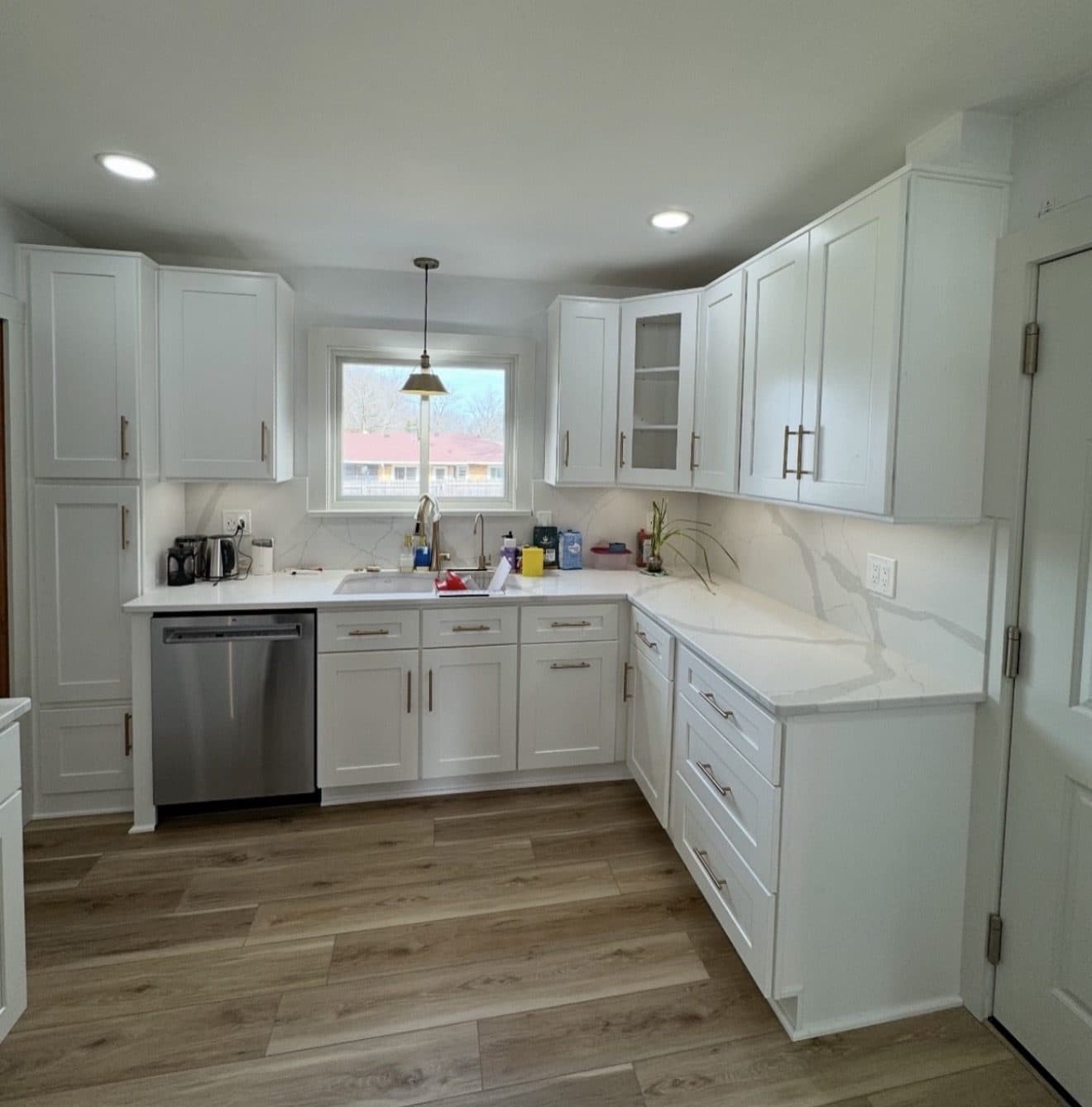 Kitchen remodel with white shaker cabinets, gold hardware, Calacatta marble full-slab backsplash, and white quartz countertops in Lake County Ohio