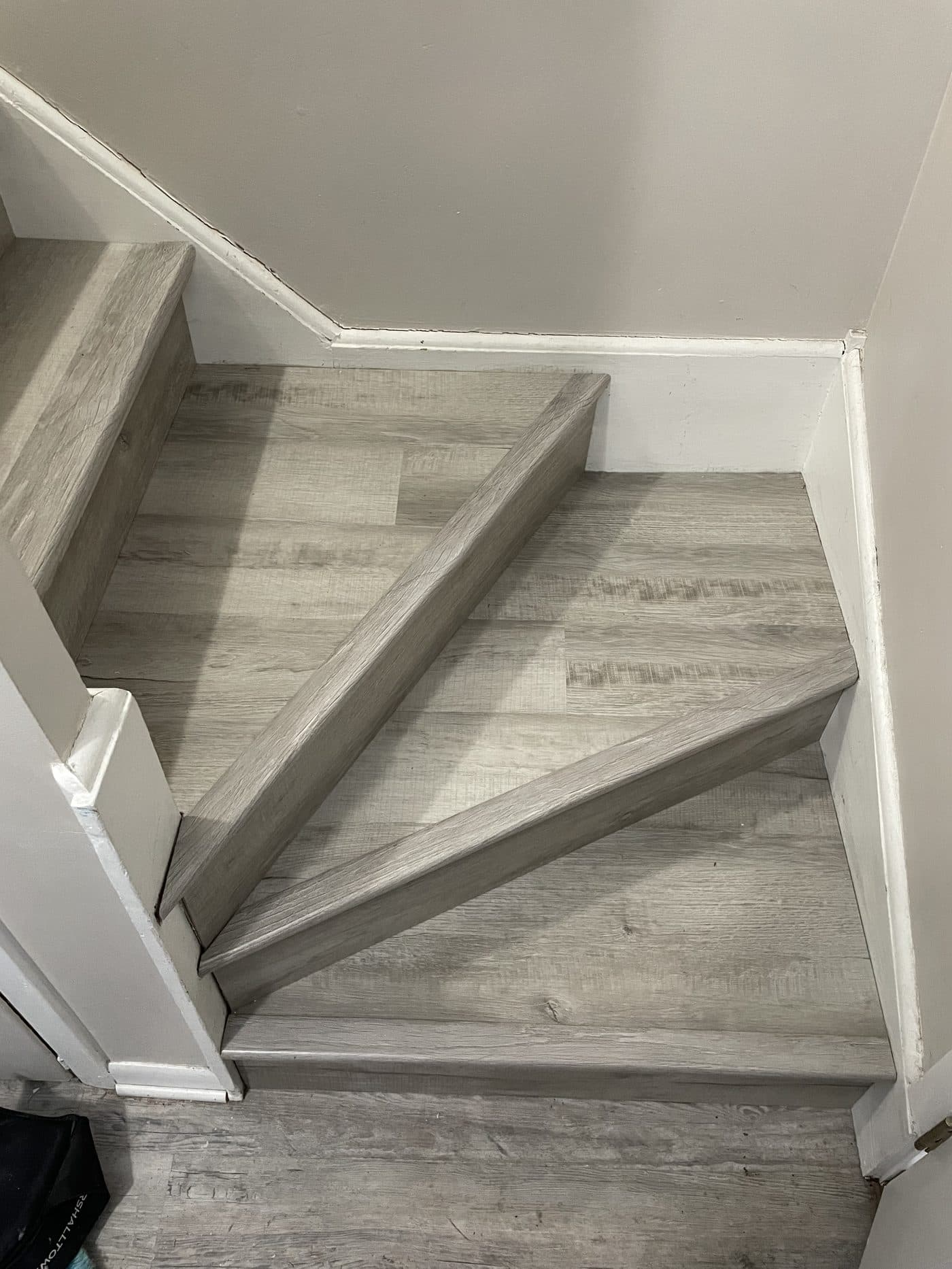 Grey luxury vinyl plank flooring installation on stairs and landing in Northeast Ohio home