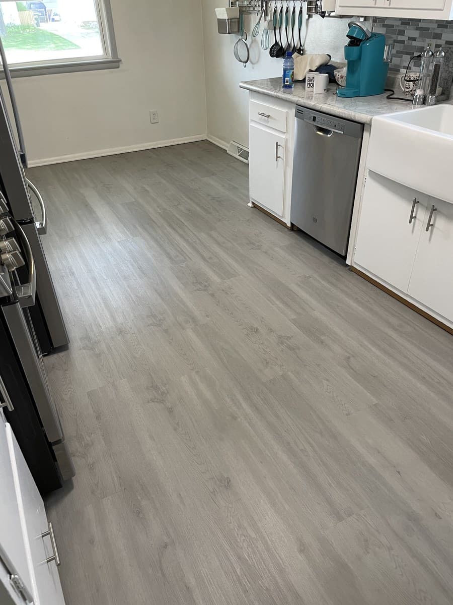 Kitchen remodel with white shaker cabinets, updated countertops, and luxury vinyl plank flooring in Lake County Ohio