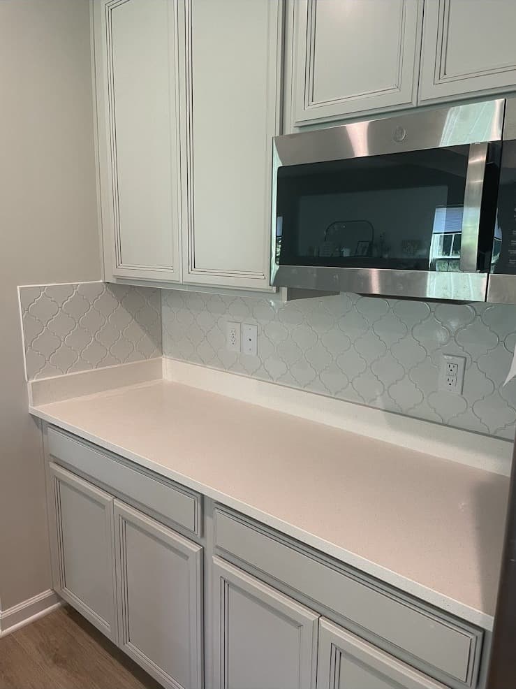 Kitchen remodel with white raised-panel cabinets, arabesque backsplash tile, and white quartz countertops in Northeast Ohio